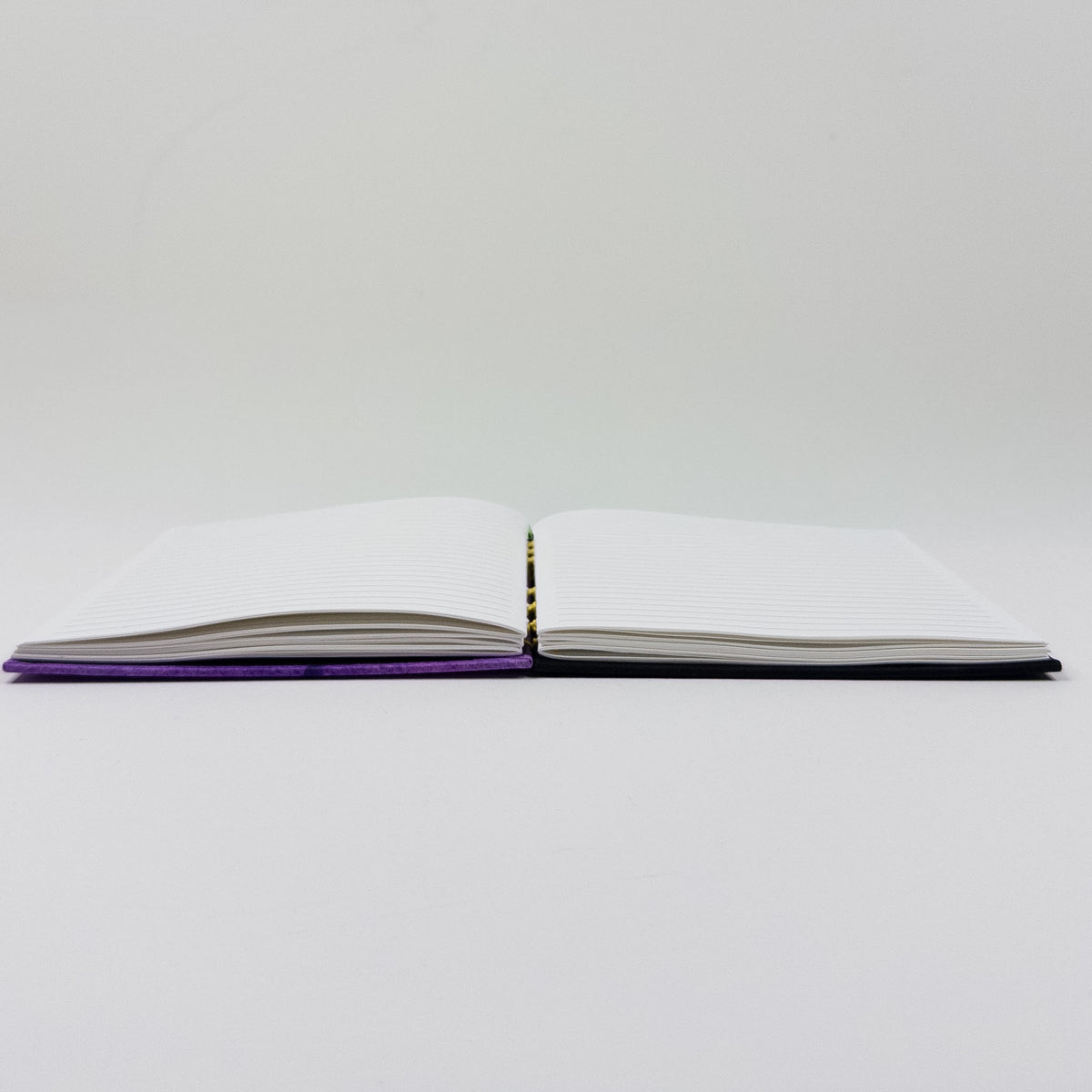 Handmade journal standing upright, showing lined pages and exposed spine