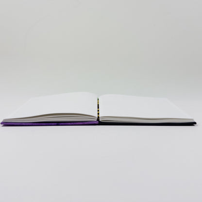 Handmade journal standing upright, showing lined pages and exposed spine