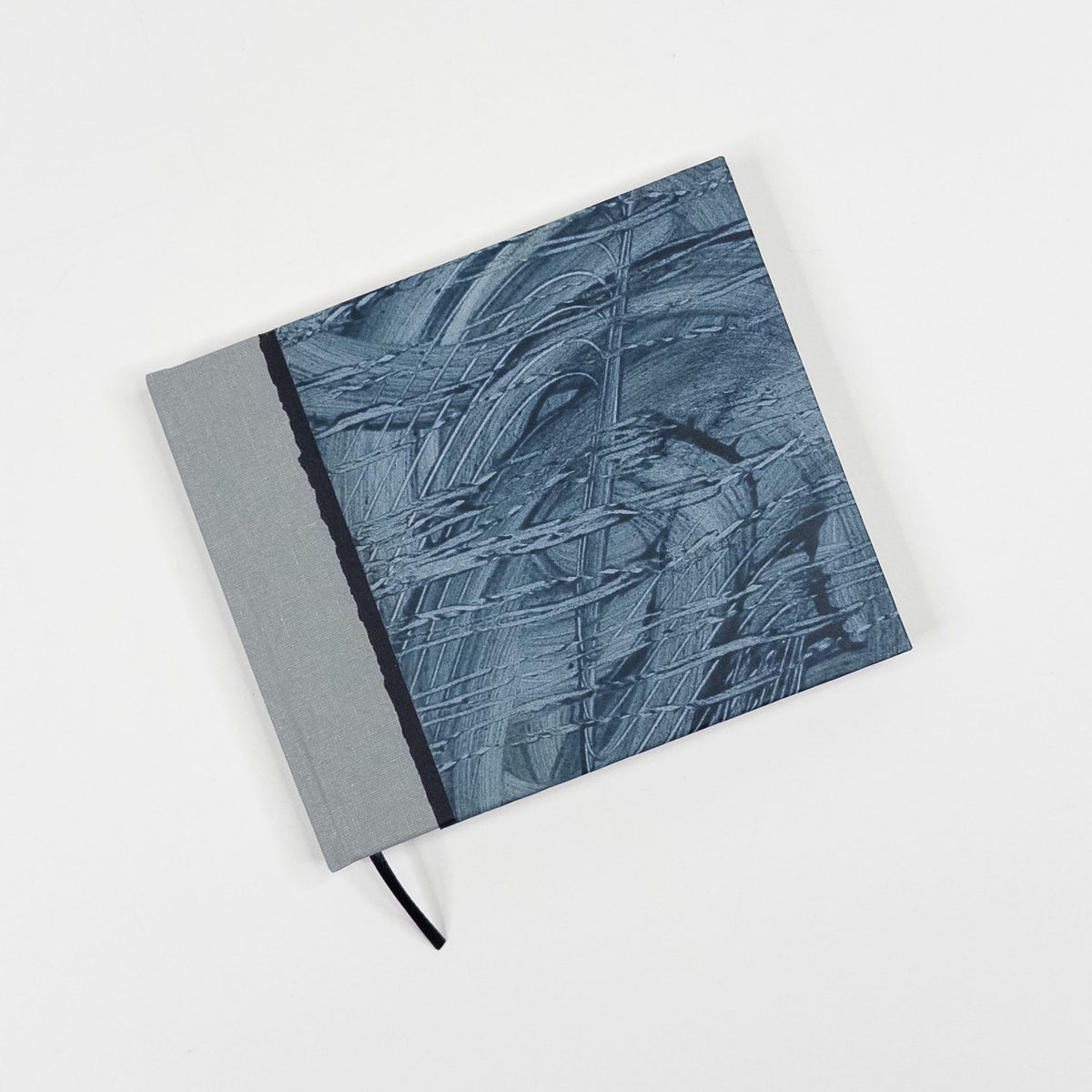 Slate and navy raked paste paper cover with grey book cloth spine and black ribbon marker, hand bound by Patti Paulus