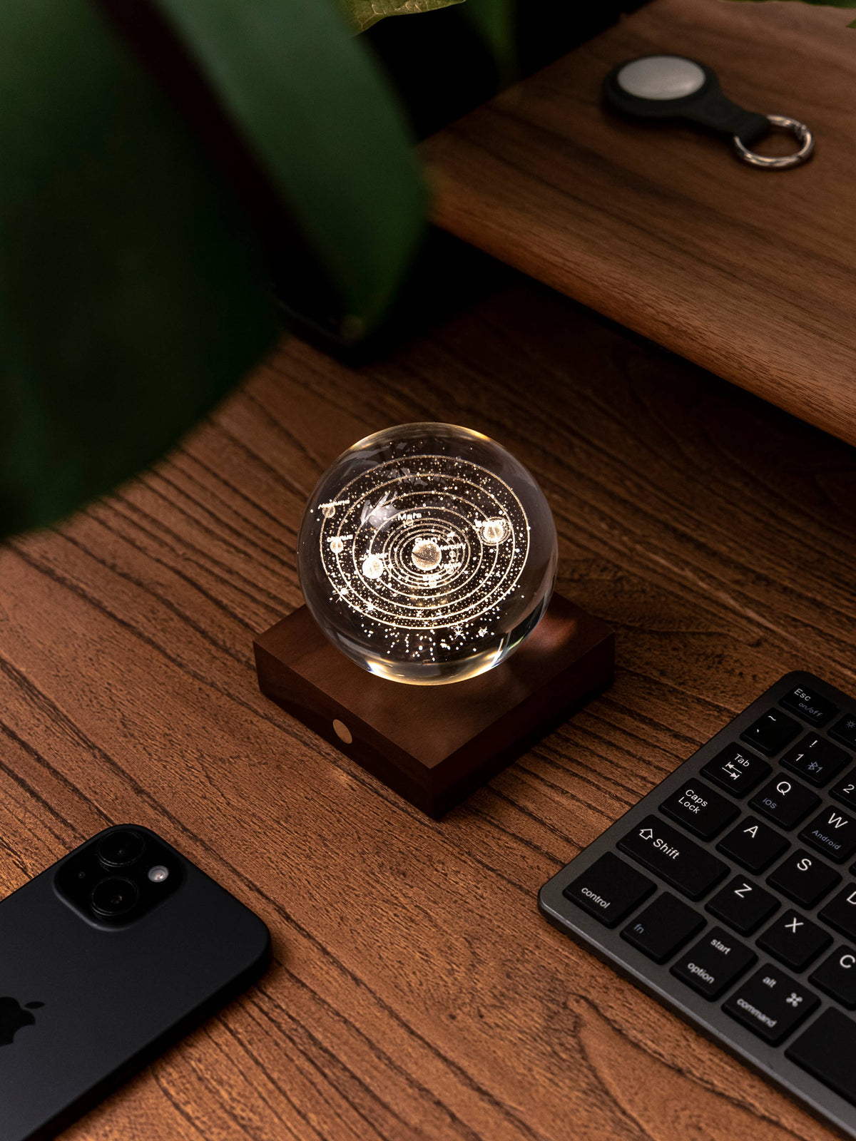 The crystal light glowing on a bedside table beside a book and a candle